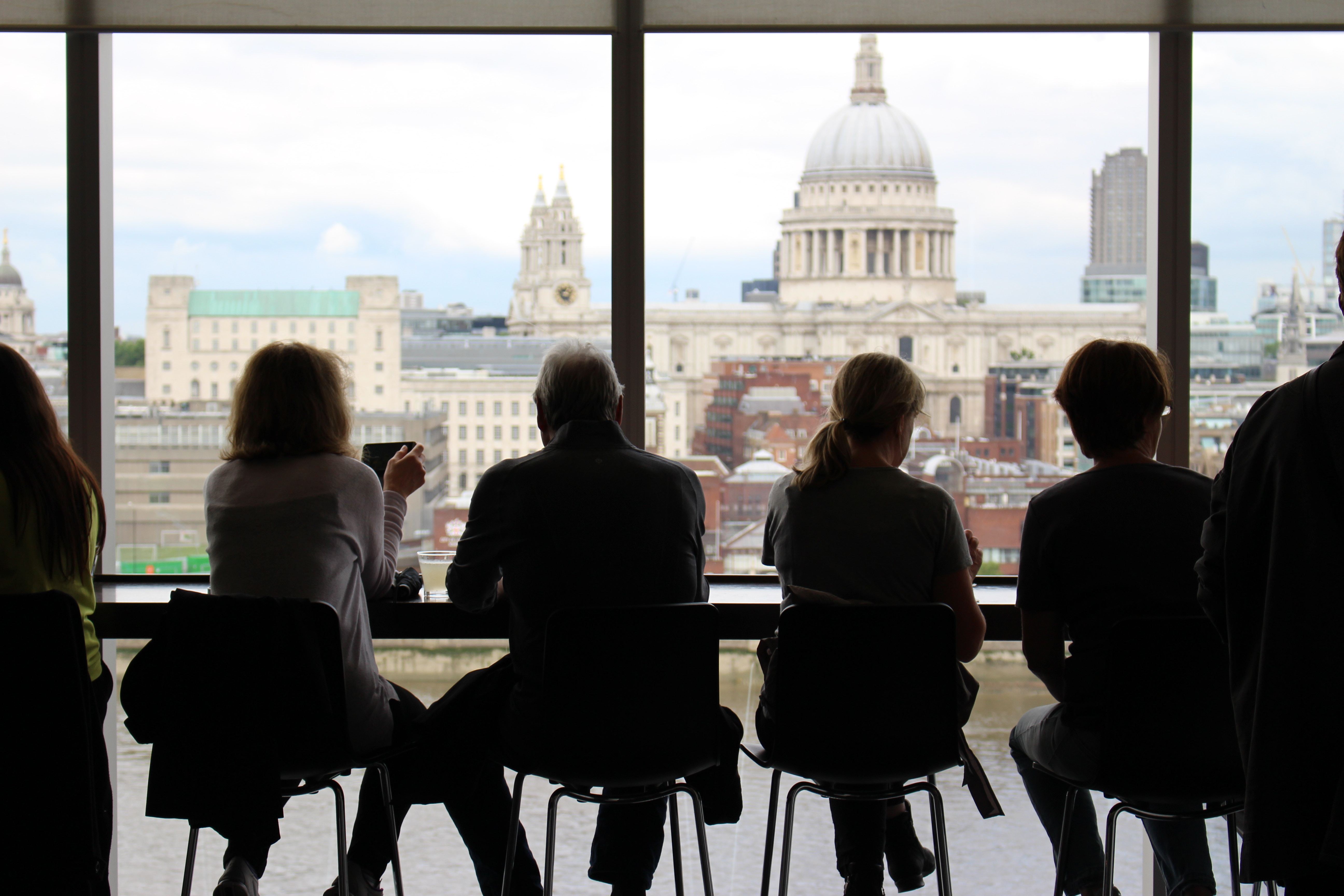 Line of people sitting looking out at a skyline through window