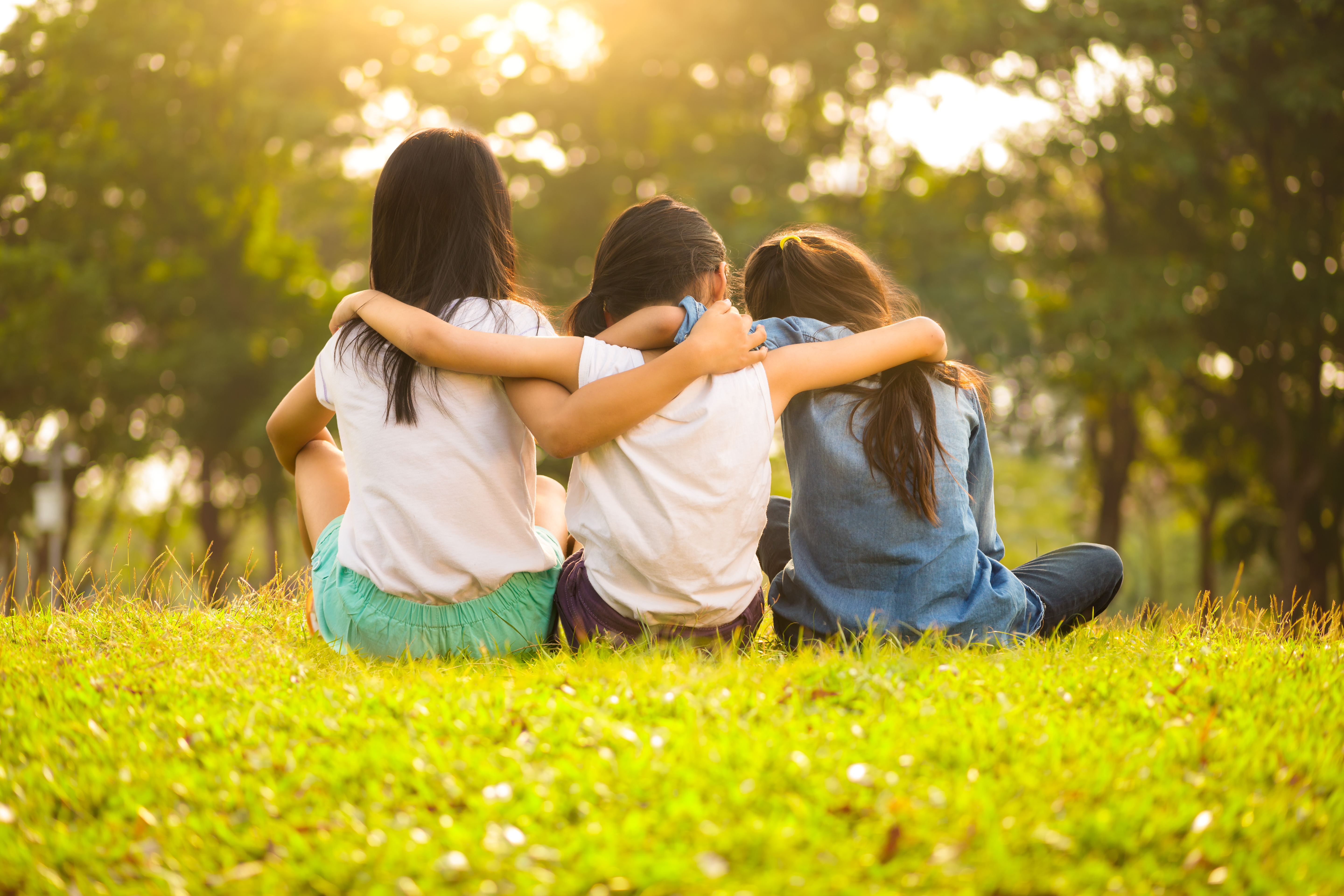 Children sitting with arms around each other