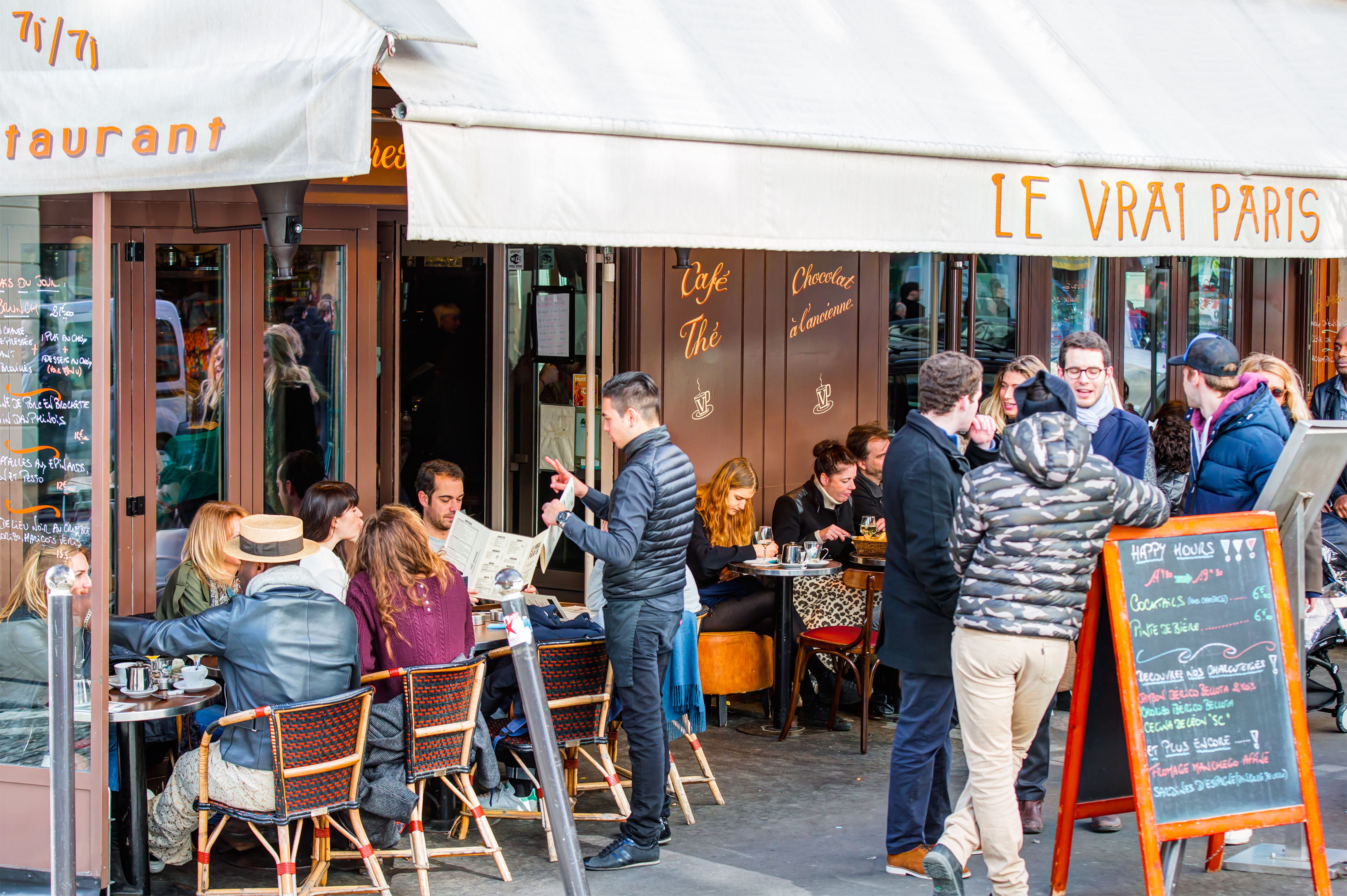 Typical view of Parisian street with cafe tables outside